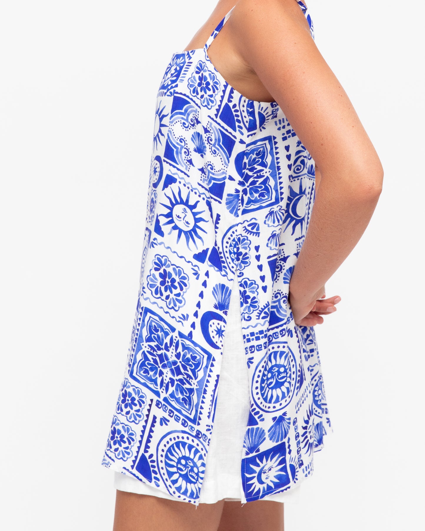 side view Close-up of a blue and white striped strappy top, featuring thin straps and a casual, summer-style design.