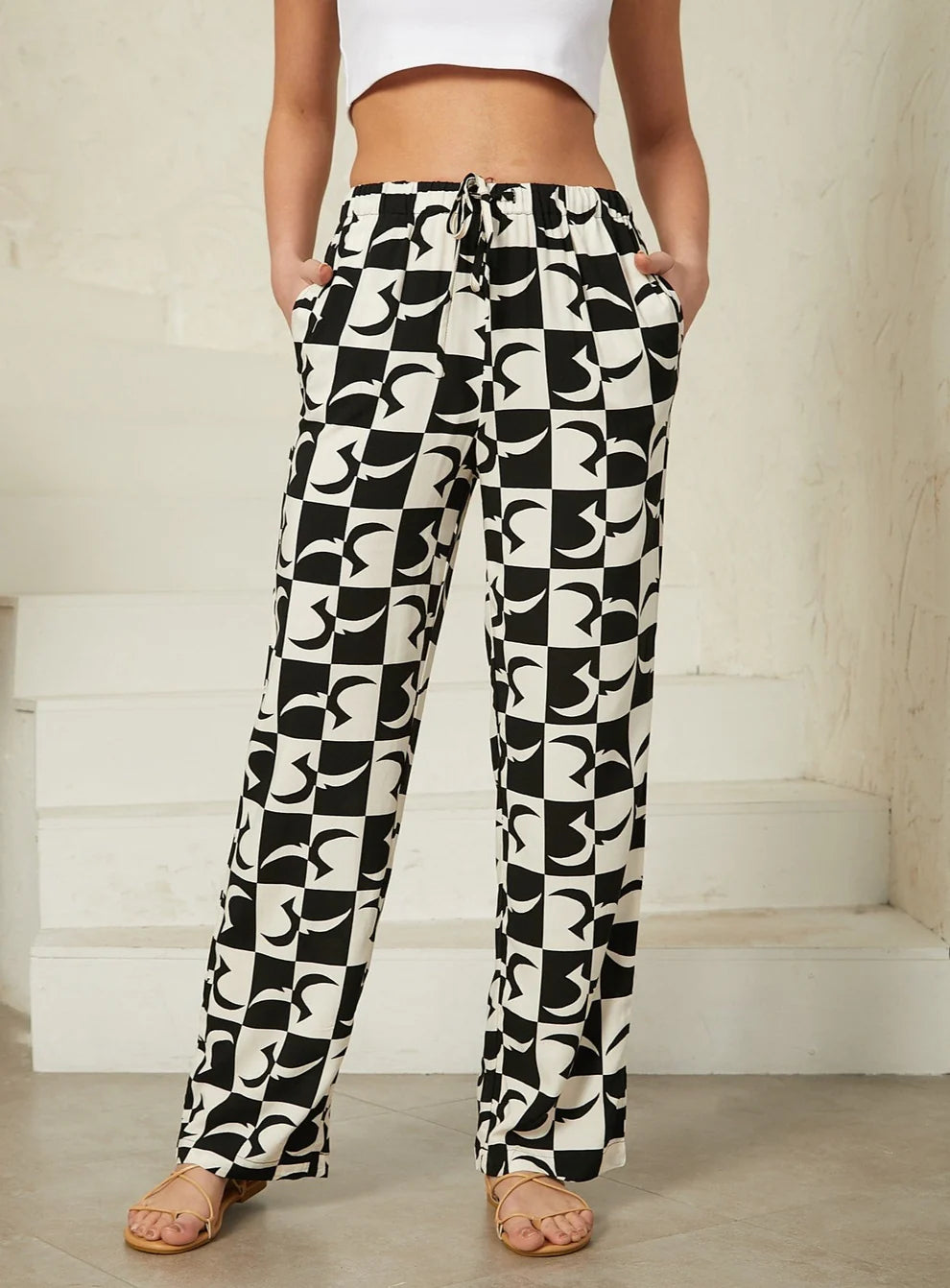Black and white geo print pants featuring a bold geometric design for a contemporary look. Relaxed design, drawstring. 
