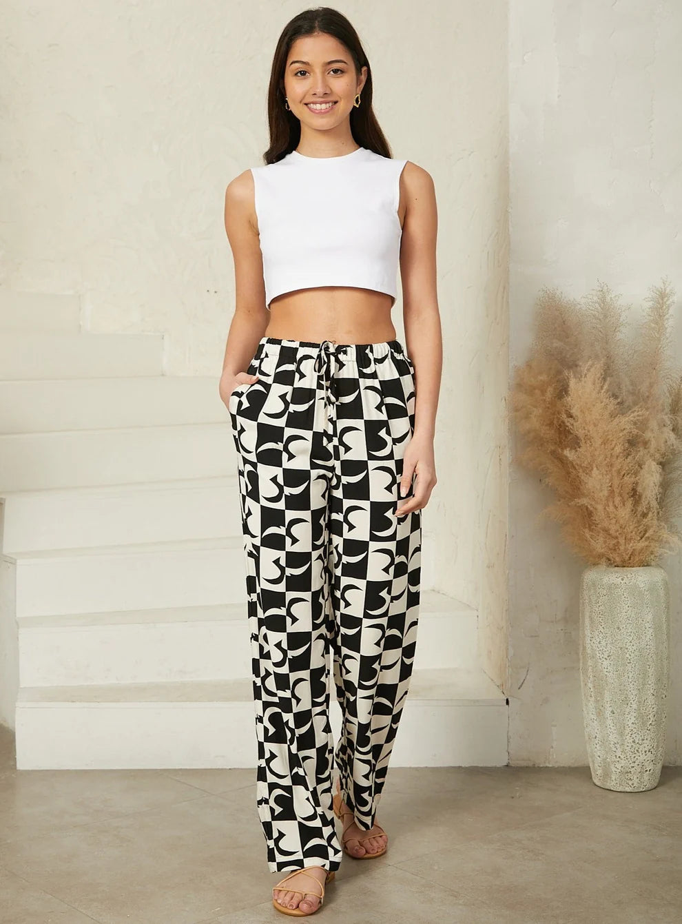 Geo print pants featuring a bold geometric design for a contemporary look with a drawstring waist, pockets. 