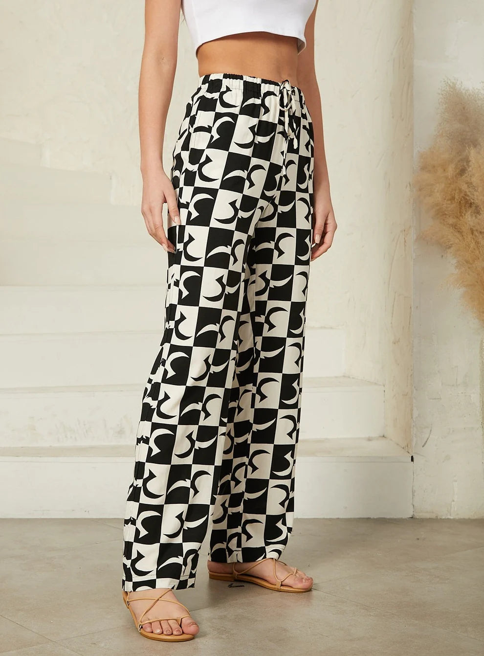 Black and white abstract print pants featuring a bold geometric design for a contemporary look. Relaxed design, drawstring. 