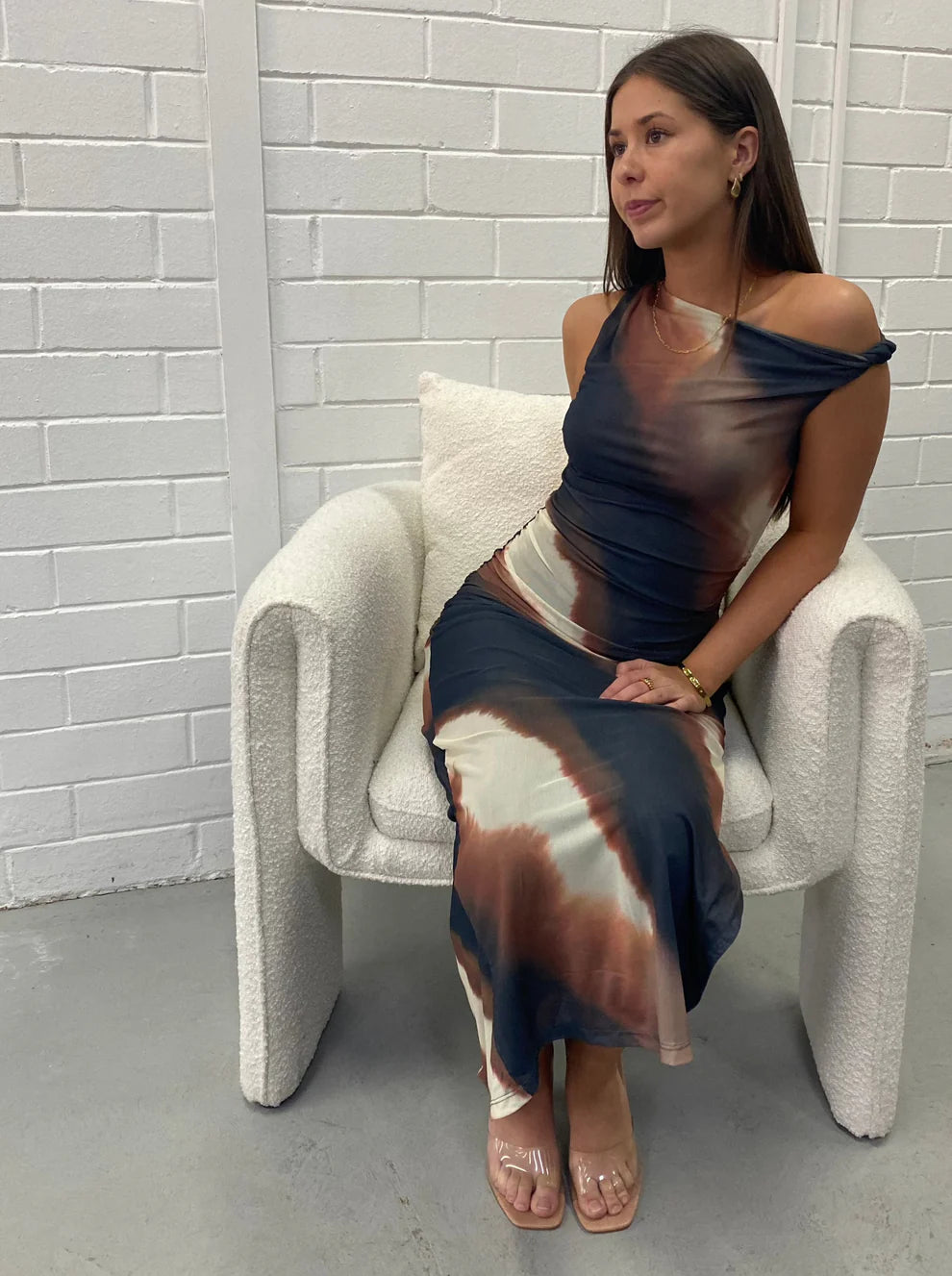 Elegant knot shoulder mesh maxi dress with sophisticated detailing and a flowing silhouette. Sitting View. 