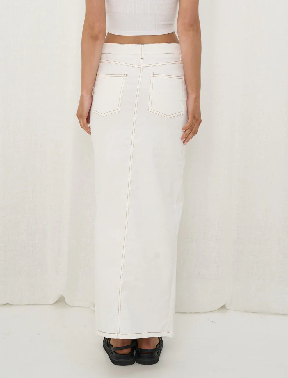 White maxi skirt with contrast stitching for a bold and modern silhouette.