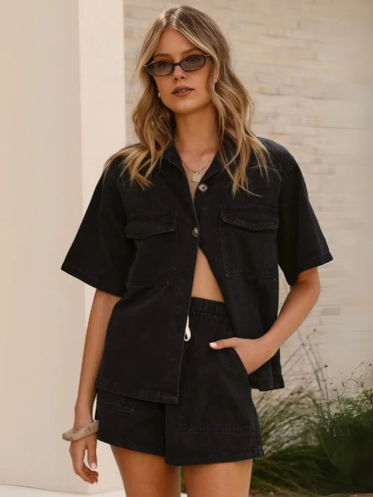 Woman wearing a black outfit with sunglasses against a neutral background